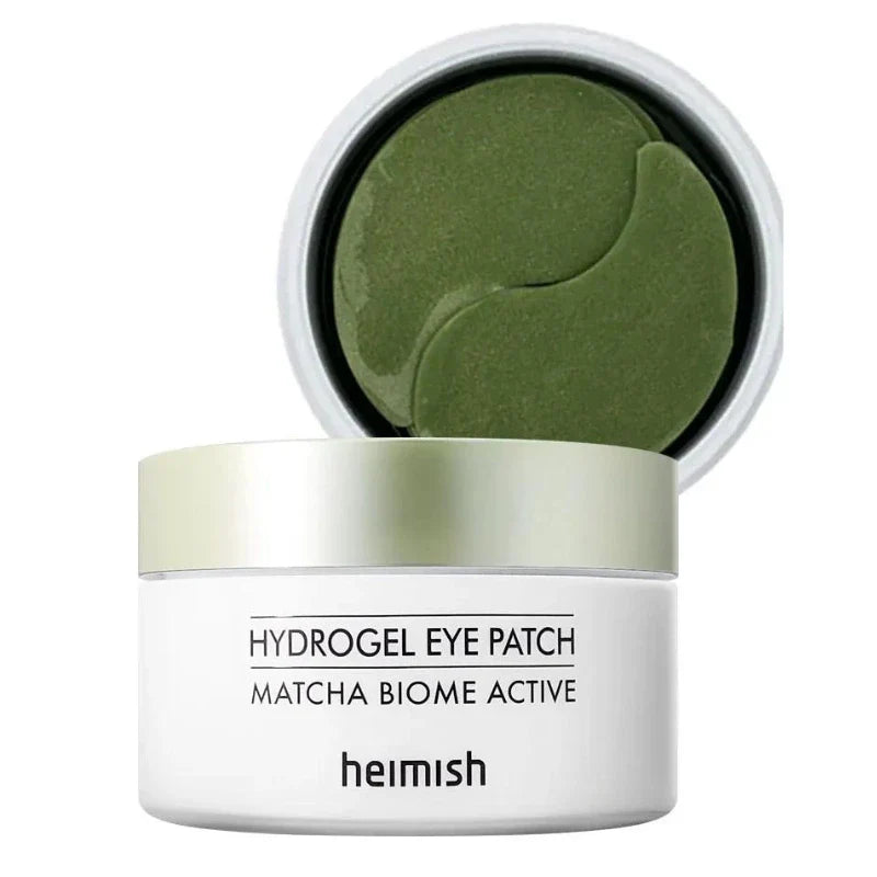 Heimish Matcha Biome Hydrogel Eye Patches in a clear container, showing individual green eye masks designed to reduce puffiness and dark circles.